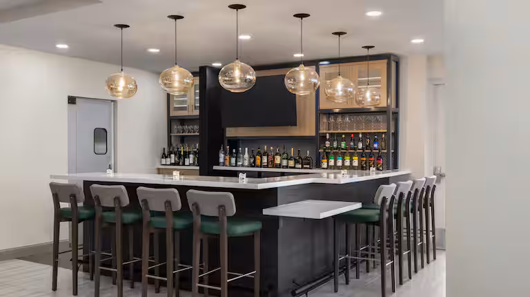 Hotel lounge bar with pendant lighting and stools